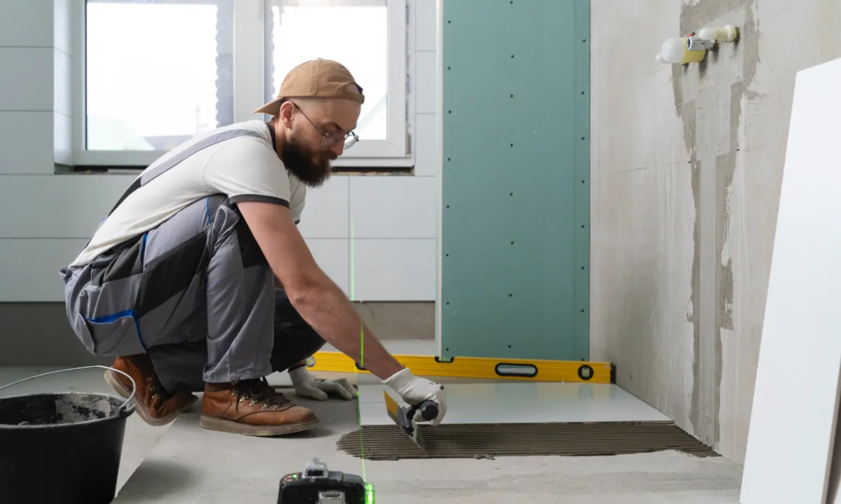 Installation de carrelage par un homme